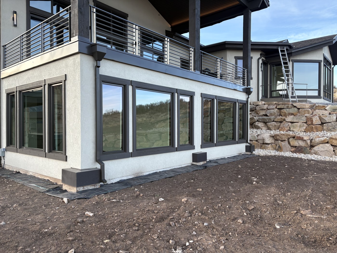 Charcoal 6-inch K-style gutter system on a modern luxury home with large windows and stone detail.
